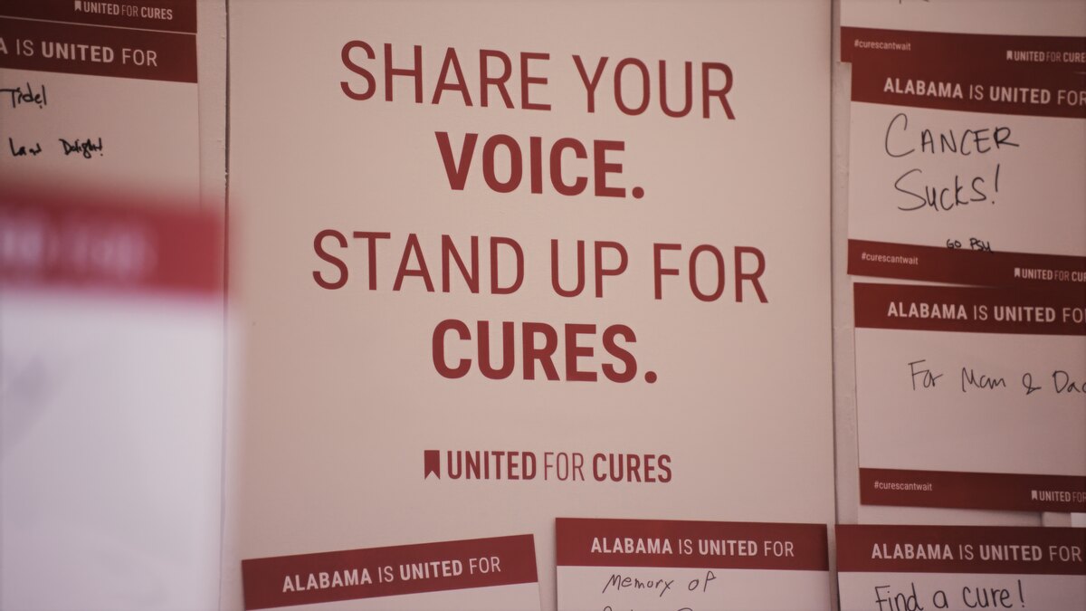 United for Cures activation — “Share your voice. Stand up for cures.” signage